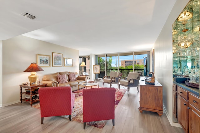 living room featuring light hardwood / wood-style floors and a wall of windows