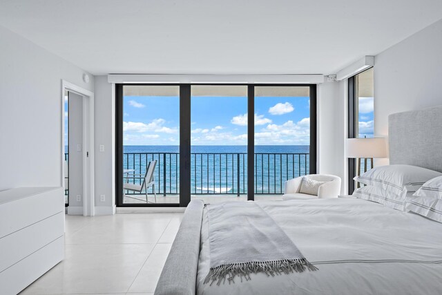 bedroom with access to exterior, floor to ceiling windows, and a water view