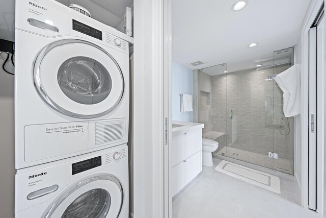 clothes washing area with stacked washer and dryer
