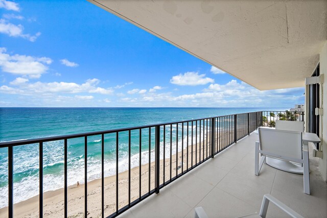 balcony with a water view and a beach view