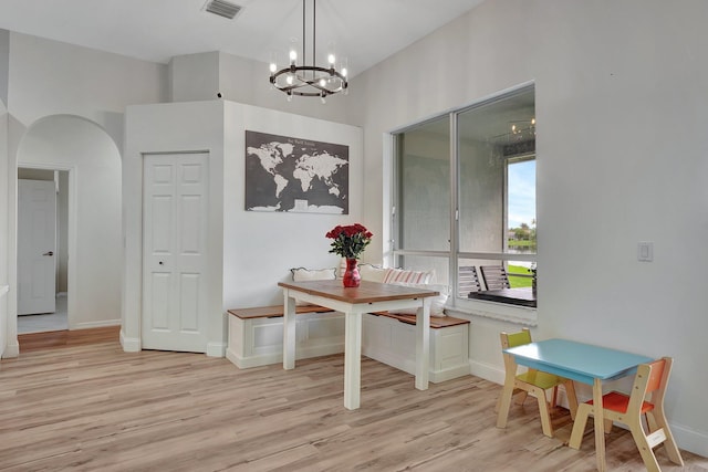 dining area with a notable chandelier and light hardwood / wood-style floors