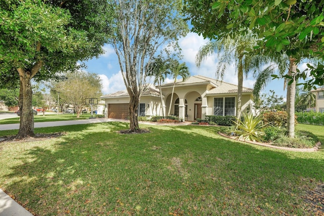 mediterranean / spanish-style home featuring a front lawn and a garage