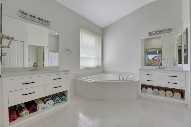 bathroom featuring vanity, lofted ceiling, tile patterned floors, and a relaxing tiled tub