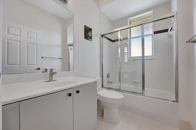 full bathroom featuring toilet, bath / shower combo with glass door, vanity, and tile patterned floors