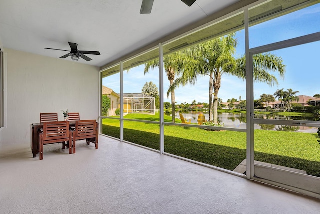 sunroom / solarium featuring a water view and ceiling fan