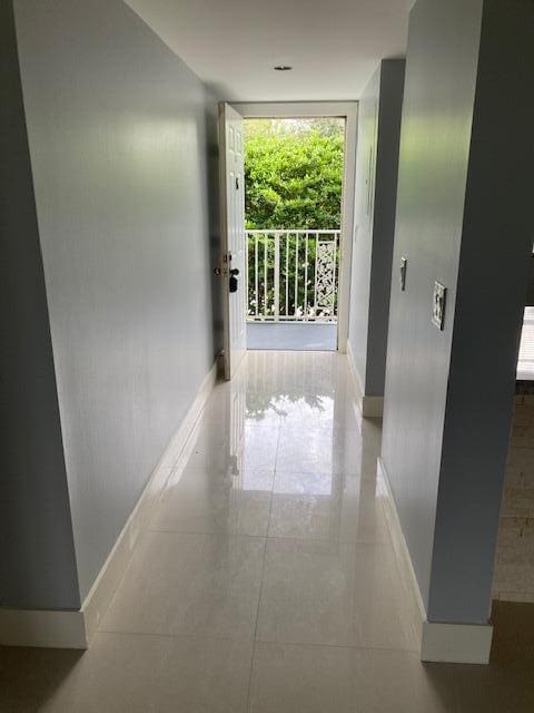 hallway with a wall of windows and tile patterned flooring