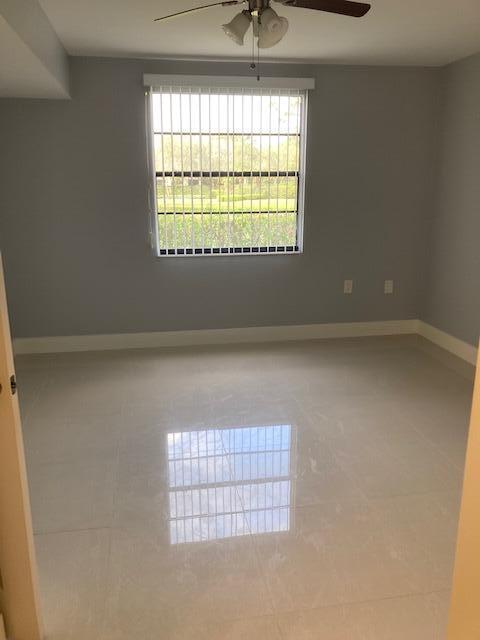 tiled empty room featuring ceiling fan