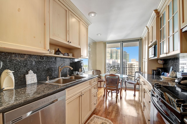 kitchen with tasteful backsplash, sink, stainless steel appliances, and light hardwood / wood-style flooring