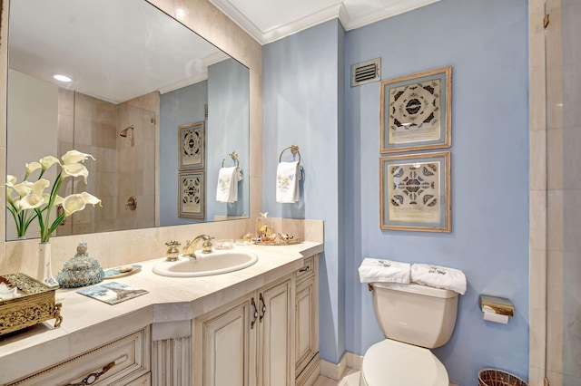 bathroom featuring toilet, a tile shower, ornamental molding, and vanity