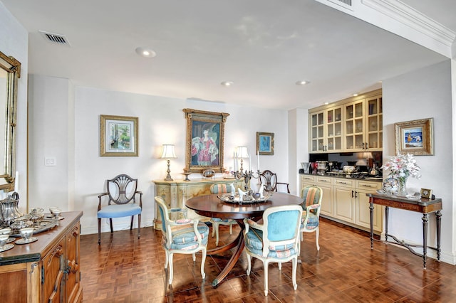 dining room featuring dark parquet floors and crown molding