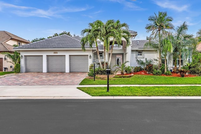 view of front of property with a front yard and a garage