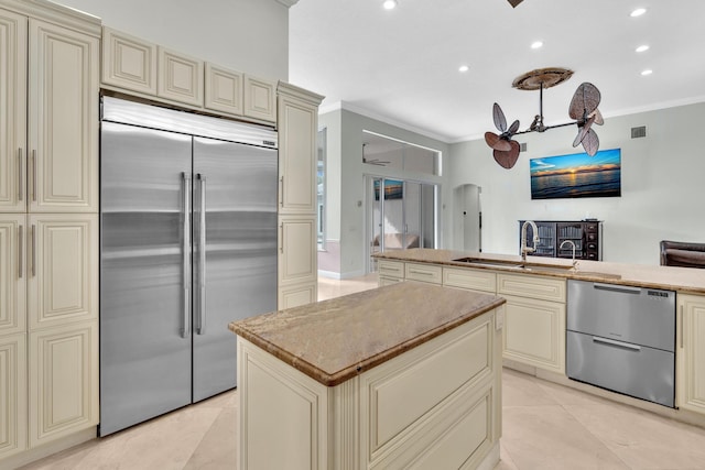 kitchen featuring appliances with stainless steel finishes, ceiling fan, crown molding, sink, and cream cabinetry