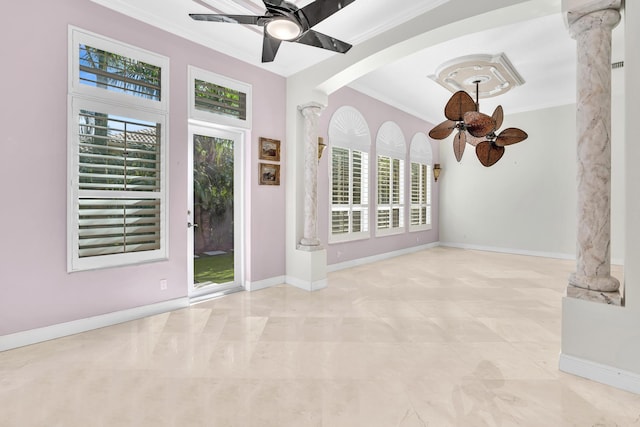 unfurnished living room with ornate columns, ceiling fan, plenty of natural light, and ornamental molding