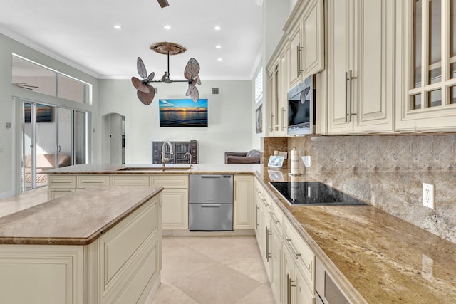 kitchen featuring a wealth of natural light, sink, cream cabinets, and appliances with stainless steel finishes