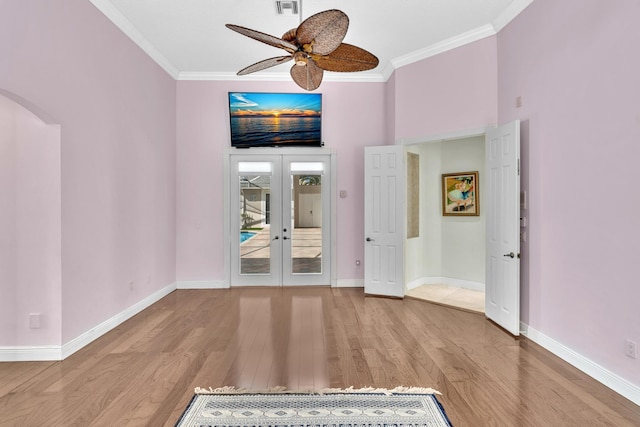 unfurnished room featuring ceiling fan, light hardwood / wood-style floors, ornamental molding, and french doors