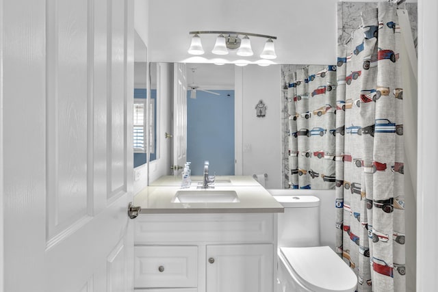 bathroom with curtained shower, ceiling fan, vanity, and toilet