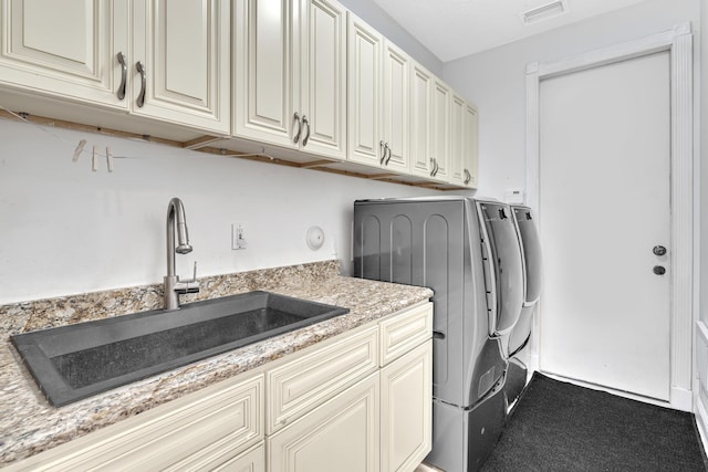 laundry area featuring carpet flooring, sink, cabinets, and independent washer and dryer