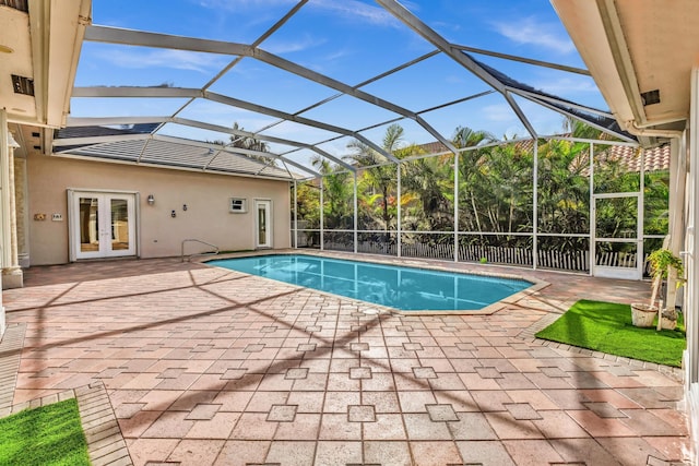 view of swimming pool with a lanai, a patio area, and french doors