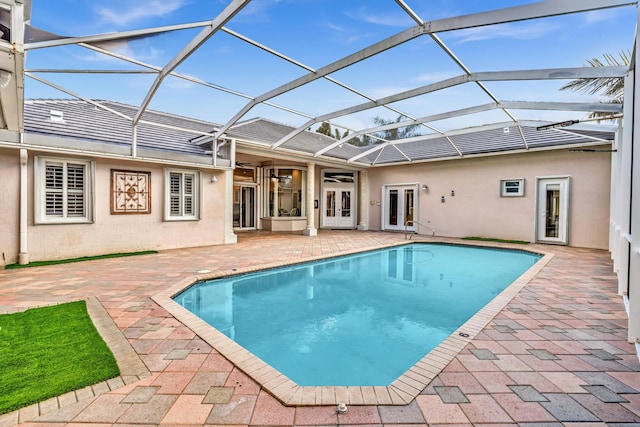 view of pool with ceiling fan, a lanai, a patio, and french doors