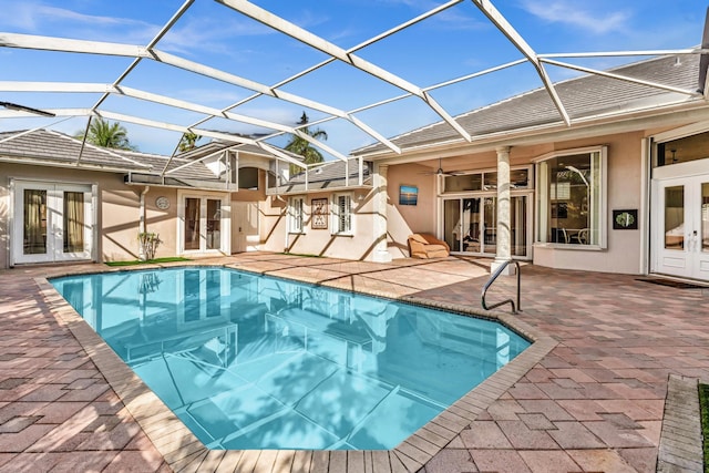 view of swimming pool with a lanai, a patio area, ceiling fan, and french doors