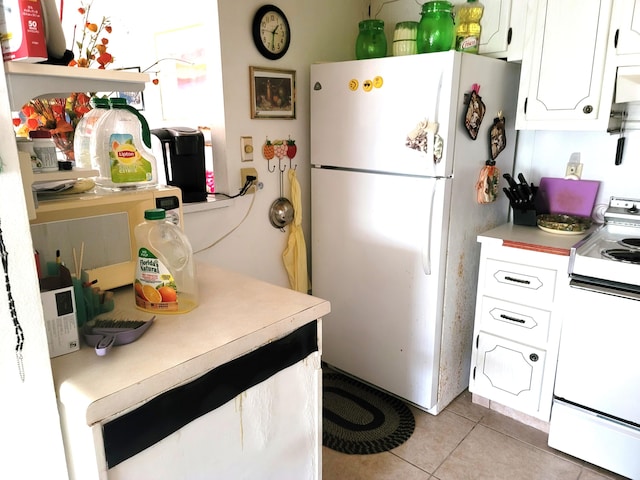 kitchen with light tile patterned floors, white appliances, and white cabinetry