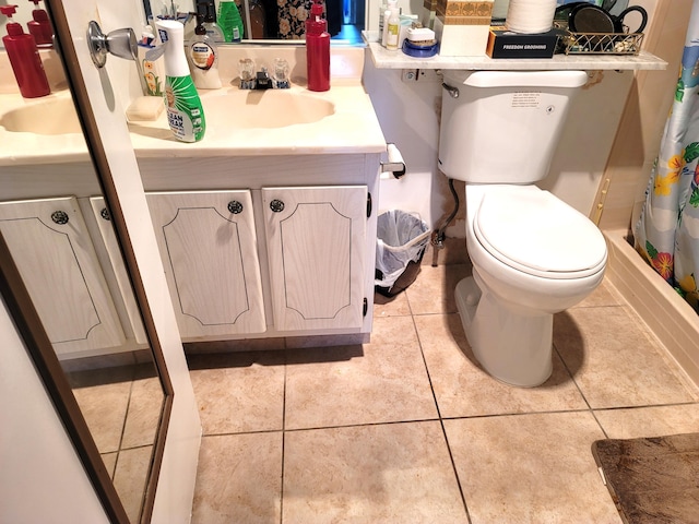 bathroom featuring tile patterned floors, vanity, curtained shower, and toilet