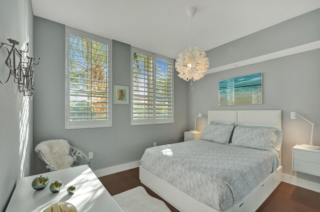 bedroom featuring dark wood-type flooring and a chandelier