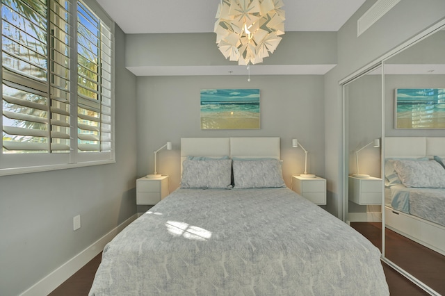 bedroom with dark wood-type flooring and a closet