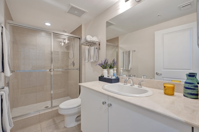 bathroom with tile patterned floors, vanity, an enclosed shower, and toilet