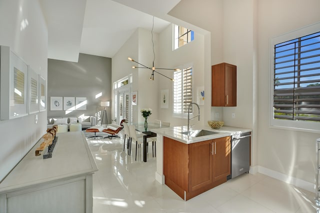 kitchen featuring dishwasher, light tile patterned floors, a high ceiling, and sink