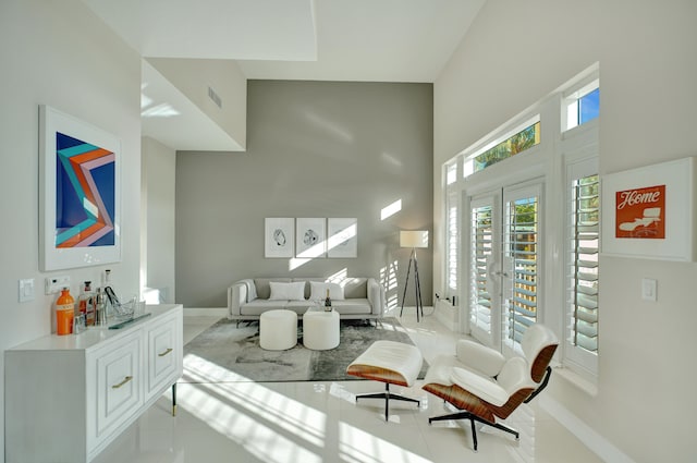 sitting room featuring light tile patterned floors and a towering ceiling