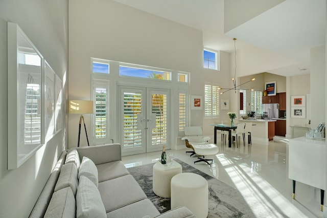 living room with a healthy amount of sunlight, a high ceiling, and an inviting chandelier