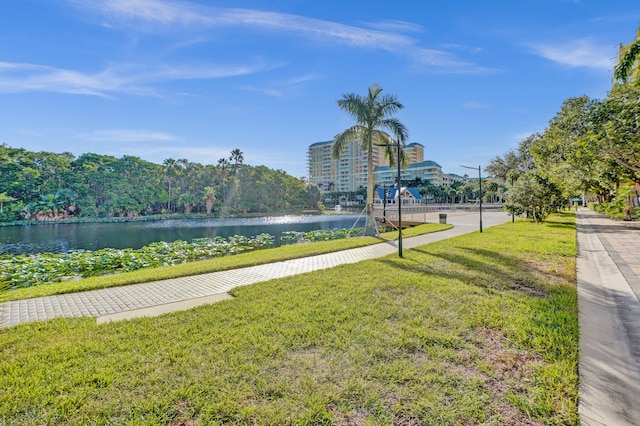 view of property's community featuring a lawn and a water view