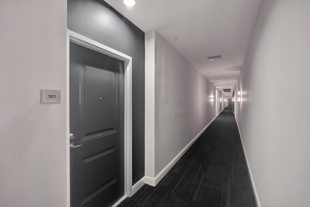 hallway with dark hardwood / wood-style flooring