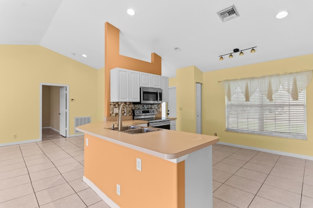 kitchen with stainless steel appliances, sink, light tile patterned floors, lofted ceiling, and white cabinets