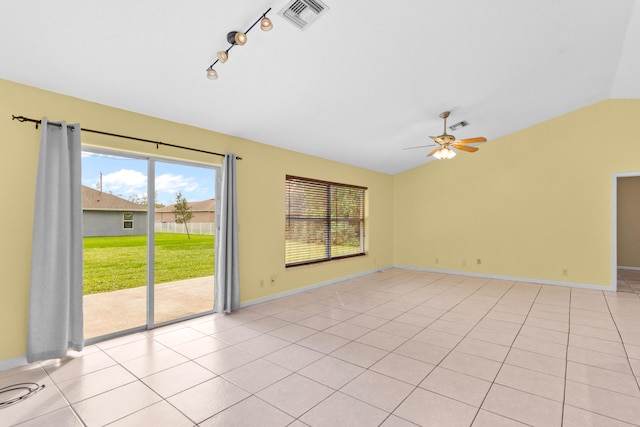 empty room featuring vaulted ceiling, light tile patterned floors, and ceiling fan