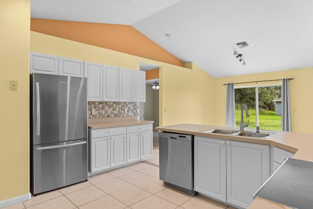 kitchen with stainless steel appliances, white cabinets, sink, and vaulted ceiling