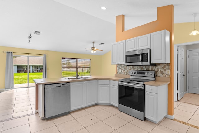 kitchen with hanging light fixtures, appliances with stainless steel finishes, sink, and white cabinets