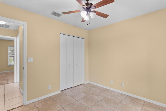 unfurnished bedroom featuring light tile patterned floors, ceiling fan, and a closet