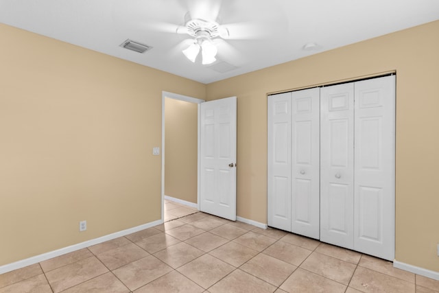 unfurnished bedroom featuring light tile patterned flooring, ceiling fan, and a closet