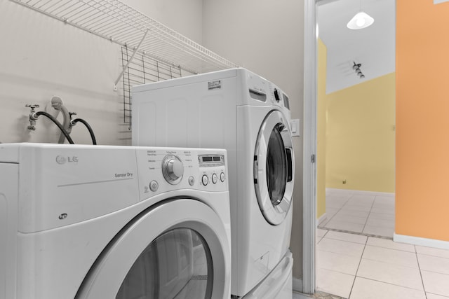 laundry room featuring light tile patterned floors and washing machine and clothes dryer