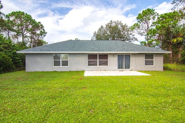 rear view of property with a yard and a patio