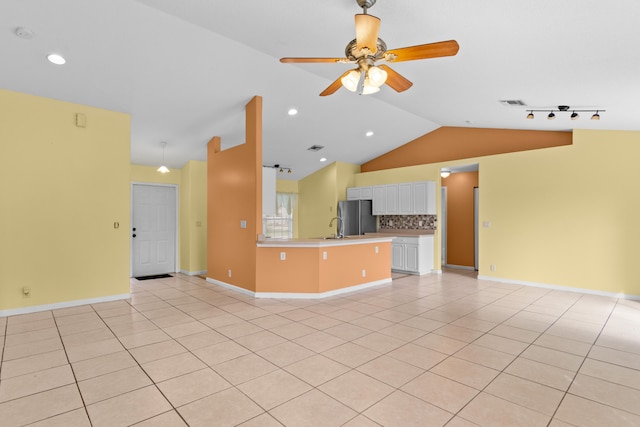 unfurnished living room with lofted ceiling, ceiling fan, and light tile patterned flooring