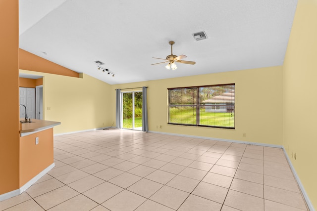 unfurnished room with lofted ceiling, light tile patterned flooring, ceiling fan, and sink