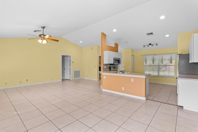 kitchen with appliances with stainless steel finishes, ceiling fan, a kitchen island with sink, lofted ceiling, and white cabinets