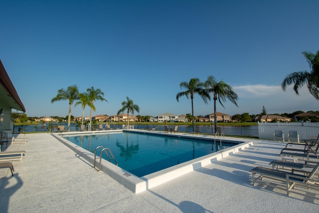 view of swimming pool with a patio area and a water view