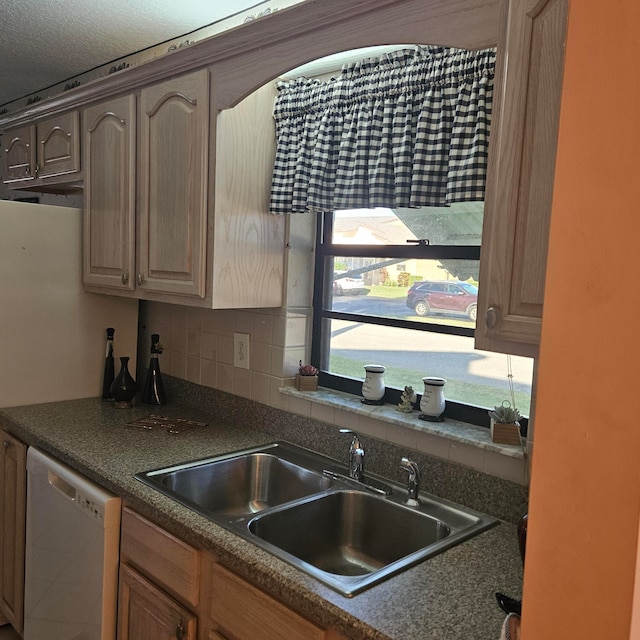 kitchen featuring backsplash, sink, and white dishwasher