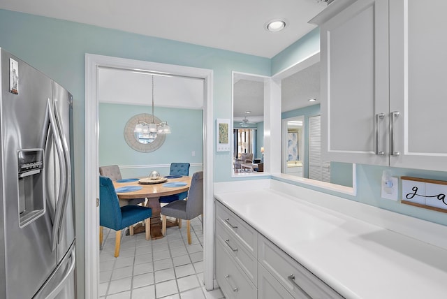 kitchen with an inviting chandelier, white cabinets, hanging light fixtures, light tile patterned floors, and stainless steel fridge with ice dispenser