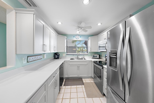 kitchen with ceiling fan, sink, light tile patterned floors, white cabinets, and appliances with stainless steel finishes