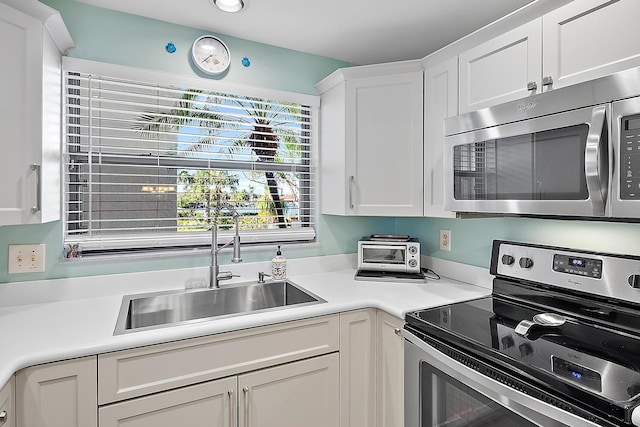 kitchen with sink, white cabinets, and stainless steel appliances